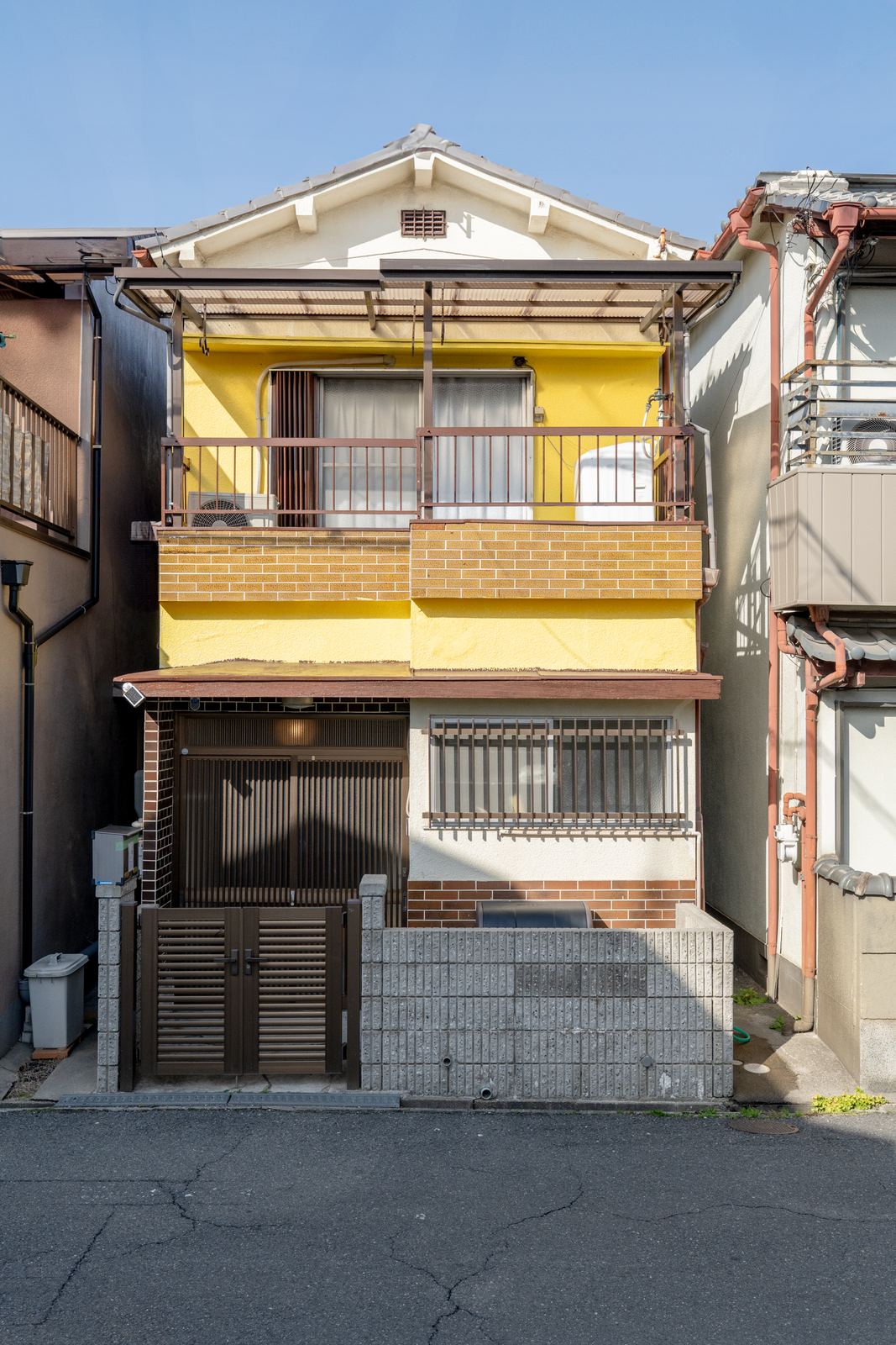 宿の外観。黄色い外壁が目印